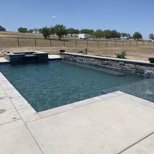 straight line pool with a concrete and tile edge