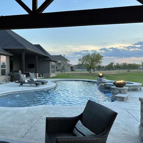 swimming pool surrounded by lawn chairs